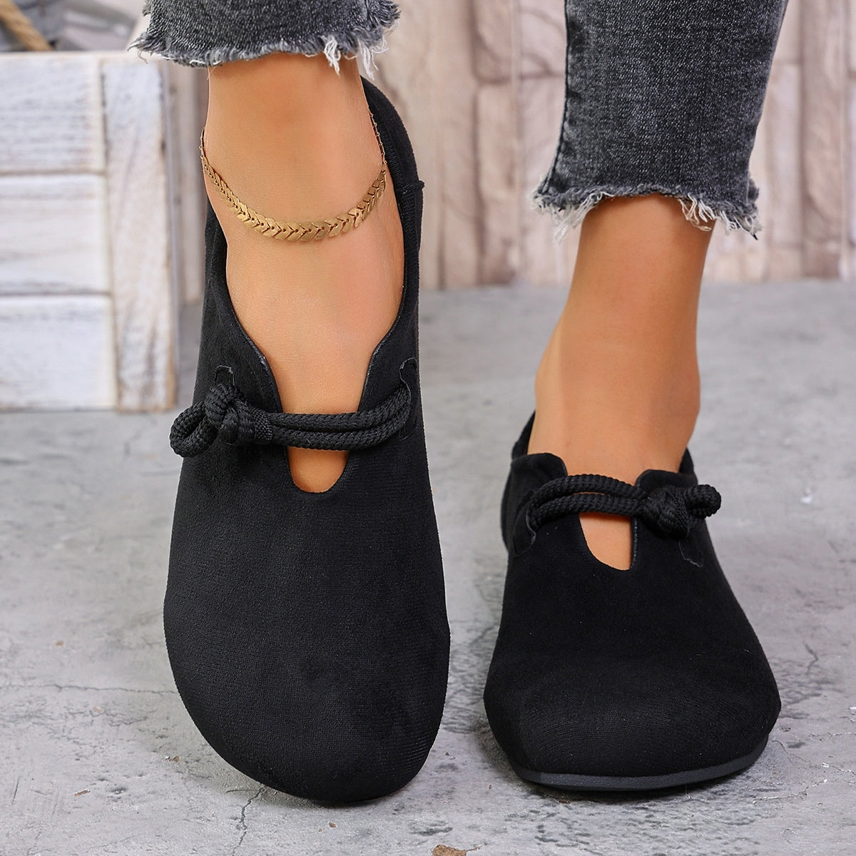Black matte fabric round toe flats with cord detail and a cutout.