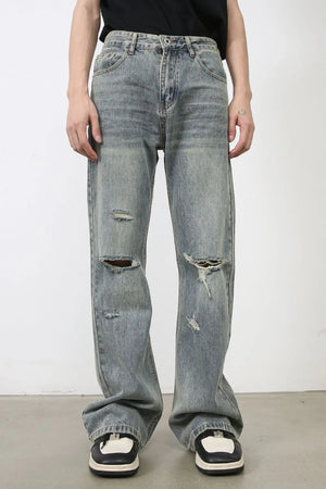 Distressed flare jeans in medium wash denim with raw-cut knee details and a relaxed fit.