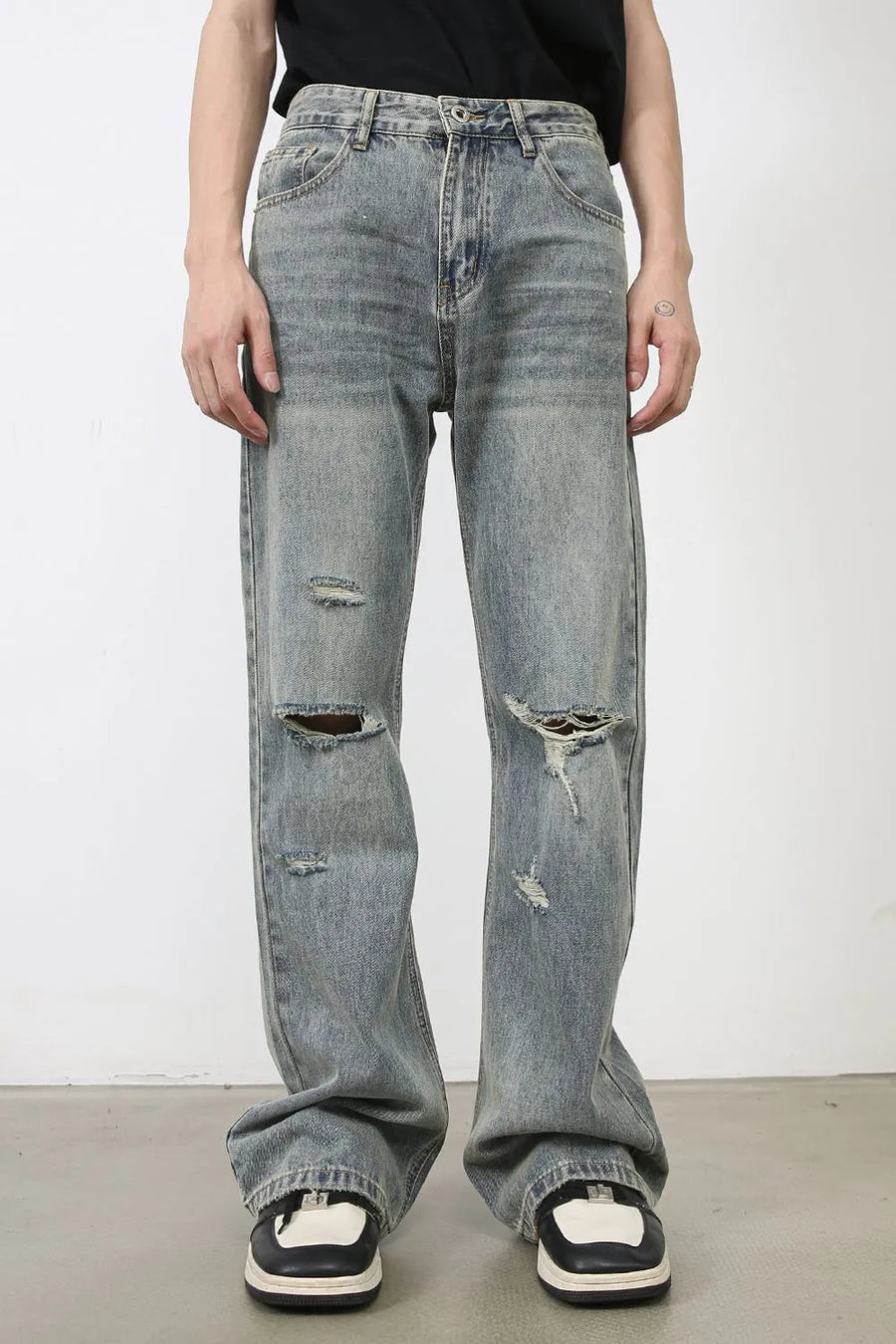 Distressed flare jeans in medium wash denim with raw-cut knee details and a relaxed fit.