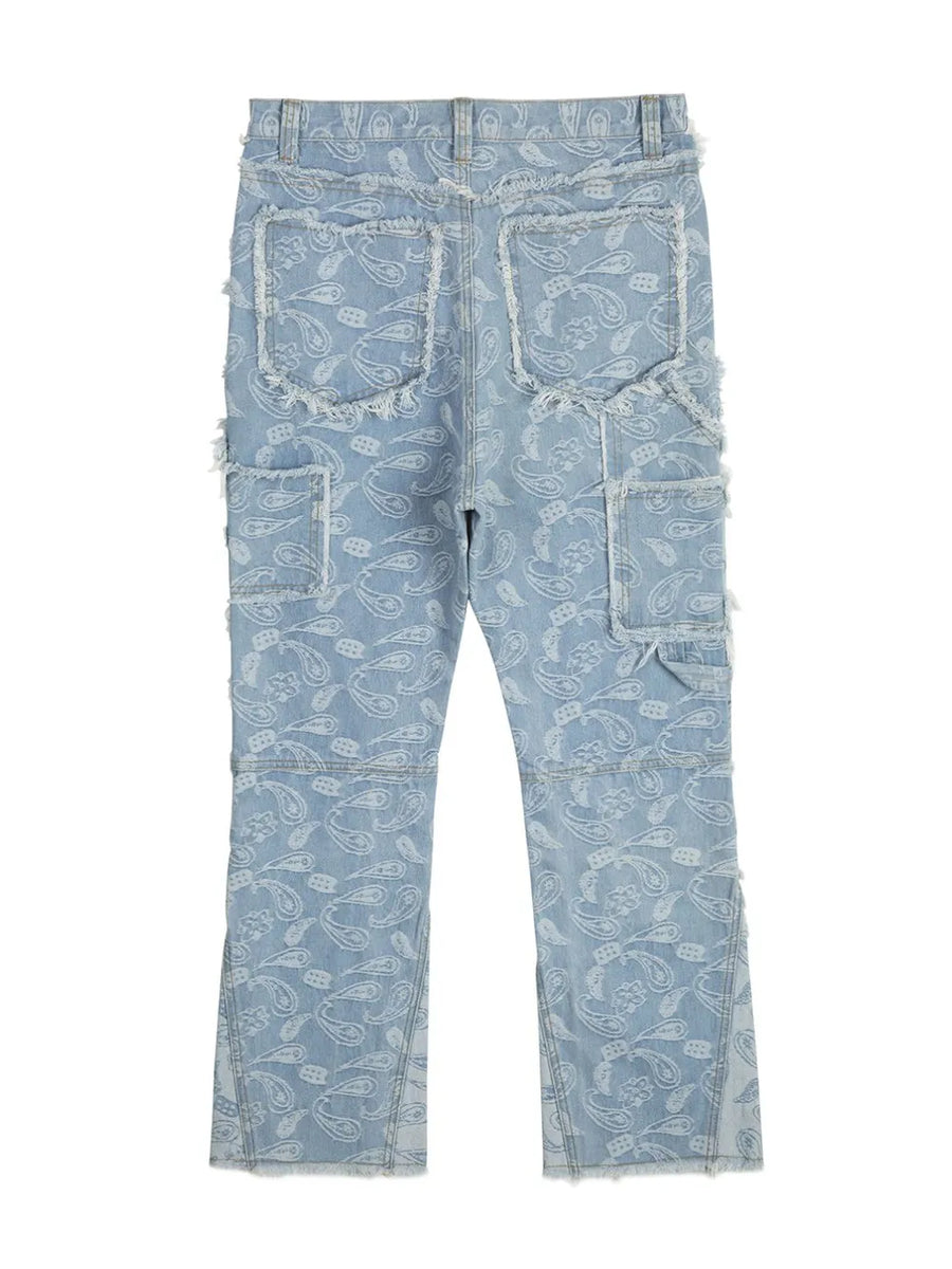 Light blue bootcut jeans with all-over white paisley print and frayed details.