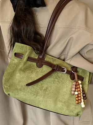 Green suede tote bag with beaded detail and brown leather straps.