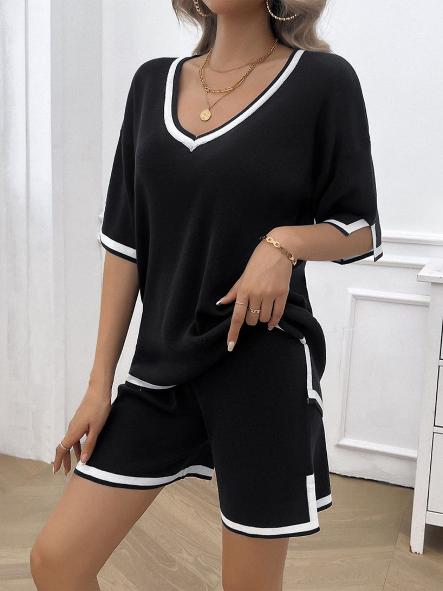 Black knit loungewear set with white contrast trim on v-neck, sleeves, and shorts.