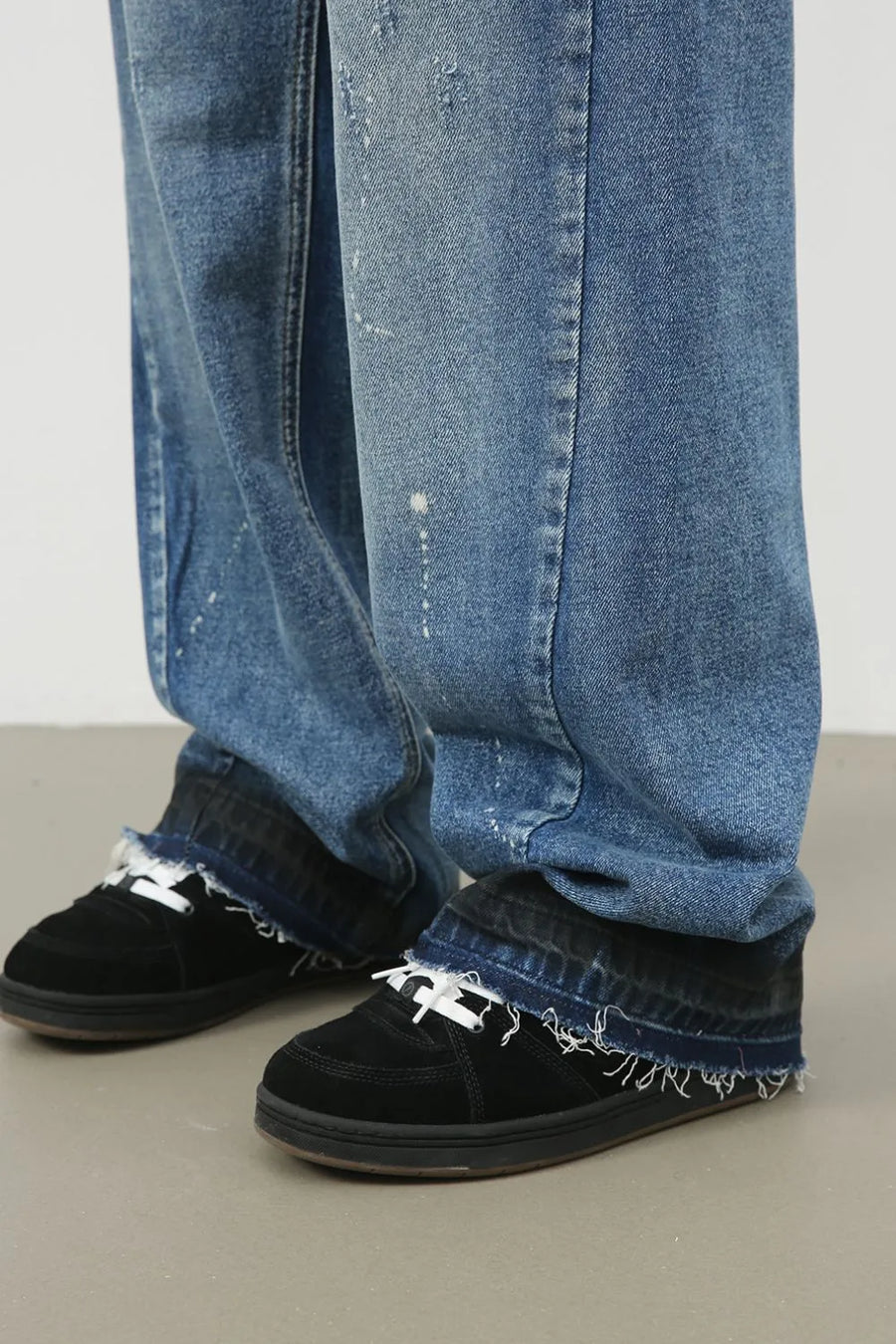 Panelled denim palazzo trousers in medium wash with distressed details and frayed hems.