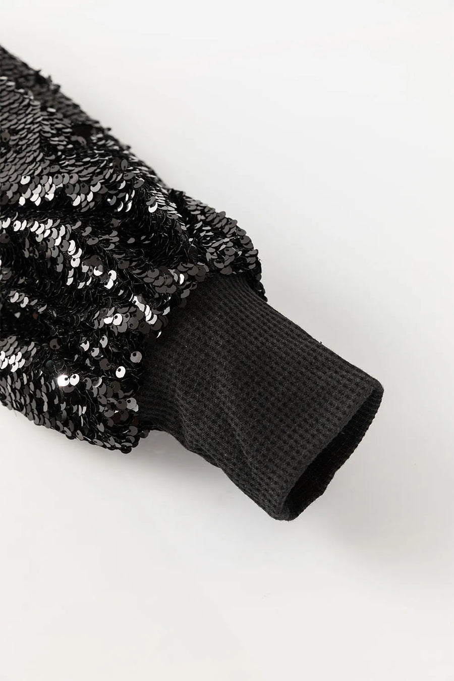 Black sequin sleeve ribbed knit top with waffle knit cuff detail.