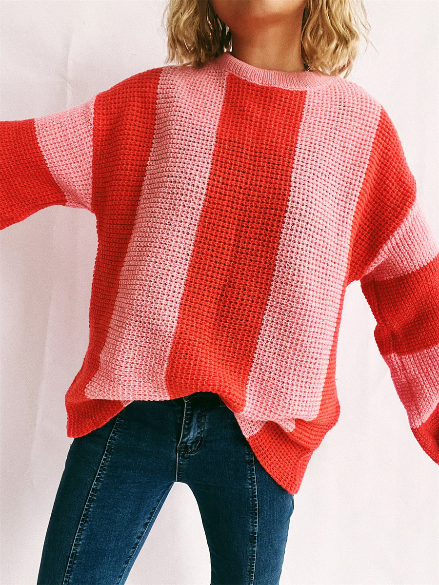 Vertical stripe waffle knit sweater in orange-red and pink, crew neck, long sleeves.