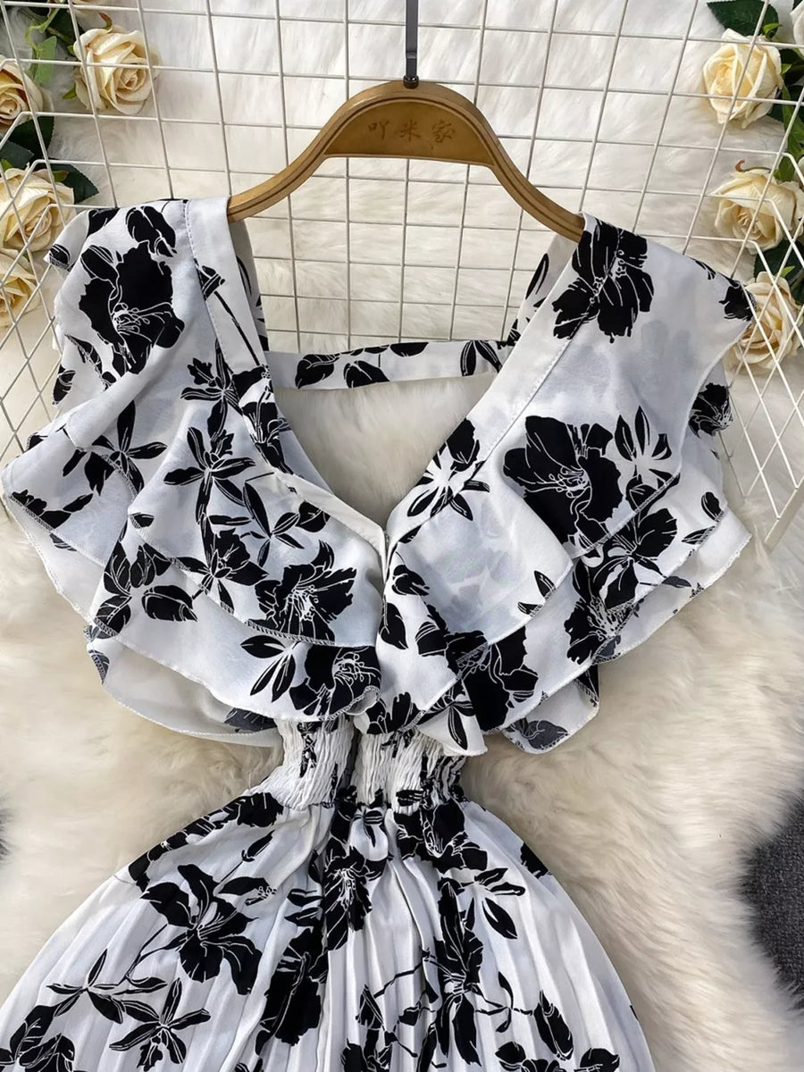 White floral print romper with ruffled sleeves, smocked waist, and pleated wide legs.