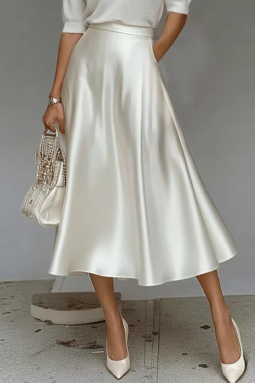 White a-line midi skirt with hidden pockets, made of lustrous satin.