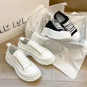 White canvas platform lace-up sneakers with chunky soles and black striped sneakers.