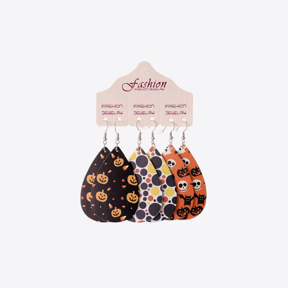 Spooky print teardrop earrings in black, orange, and white with pumpkins, skulls, and candy corn patterns.