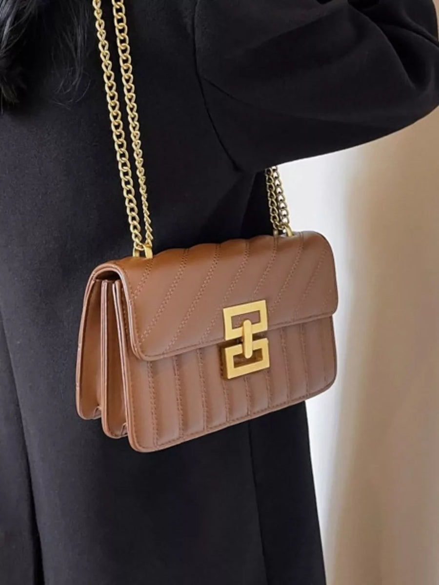 Chic quilted crossbody bag in brown with gold chain strap and gold clasp.