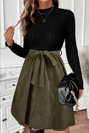 Belted ribbed A-line dress in black with a green tie belt and flared skirt.