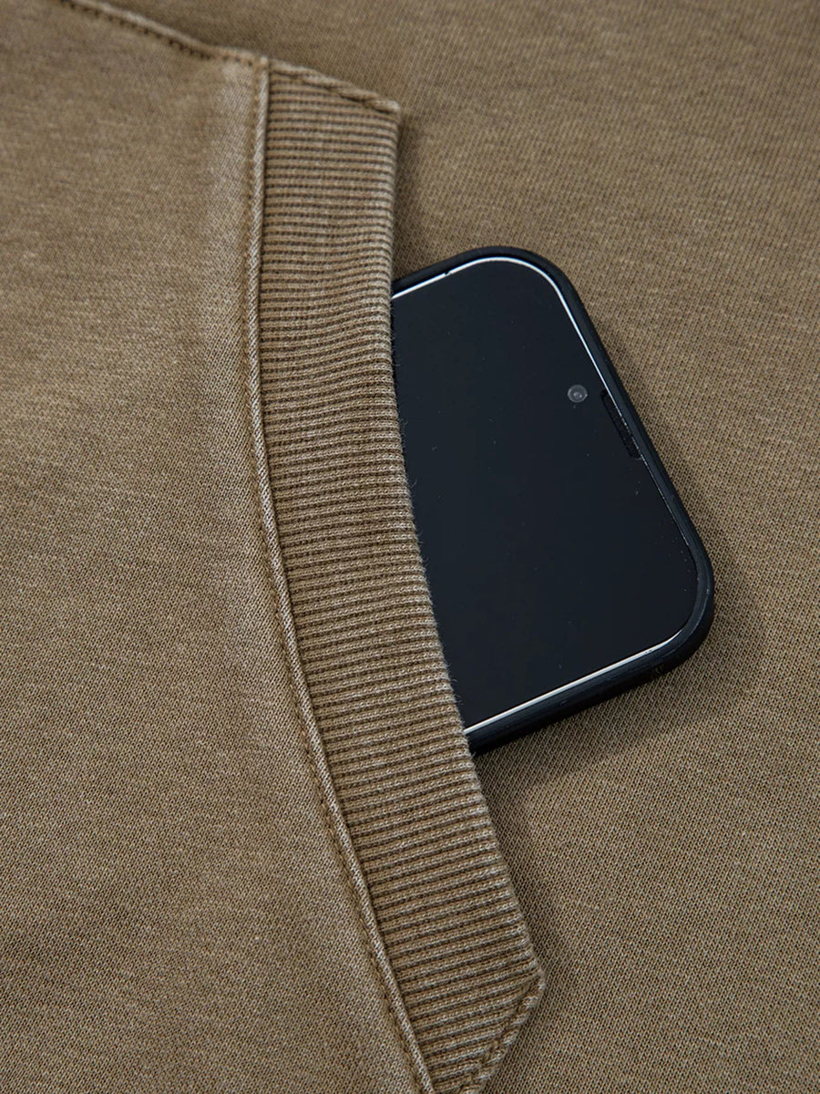 Mineral wash coffee brown hoodie with a phone in the pocket and ribbed trim detail.