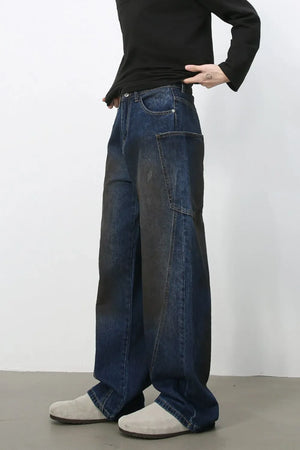 Faded panel wide-leg denim trousers in medium wash with a relaxed fit.