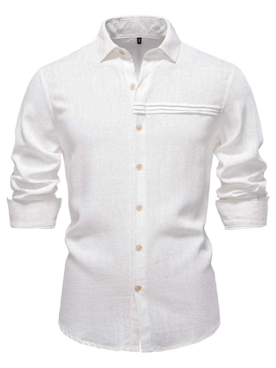 White linen button-up shirt with pleated pocket detail and rolled sleeves.