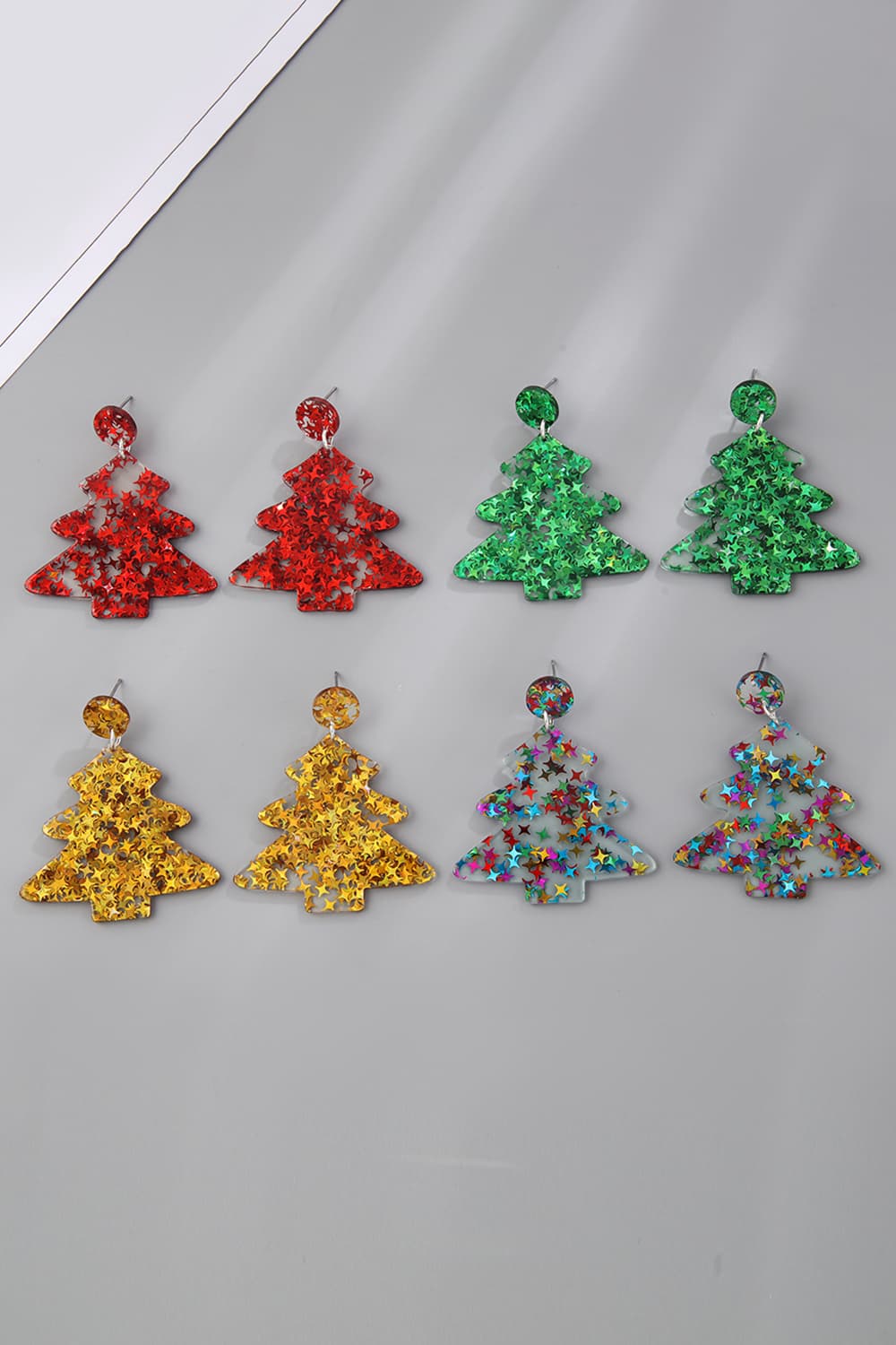 Star-studded Christmas tree drop earrings in red, green, gold, and multi-color acrylic.