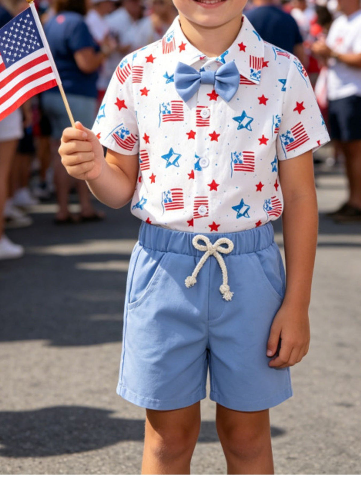 Baby patriotic shirt with American flag and star print, blue bow tie, and matching blue shorts with drawstring.