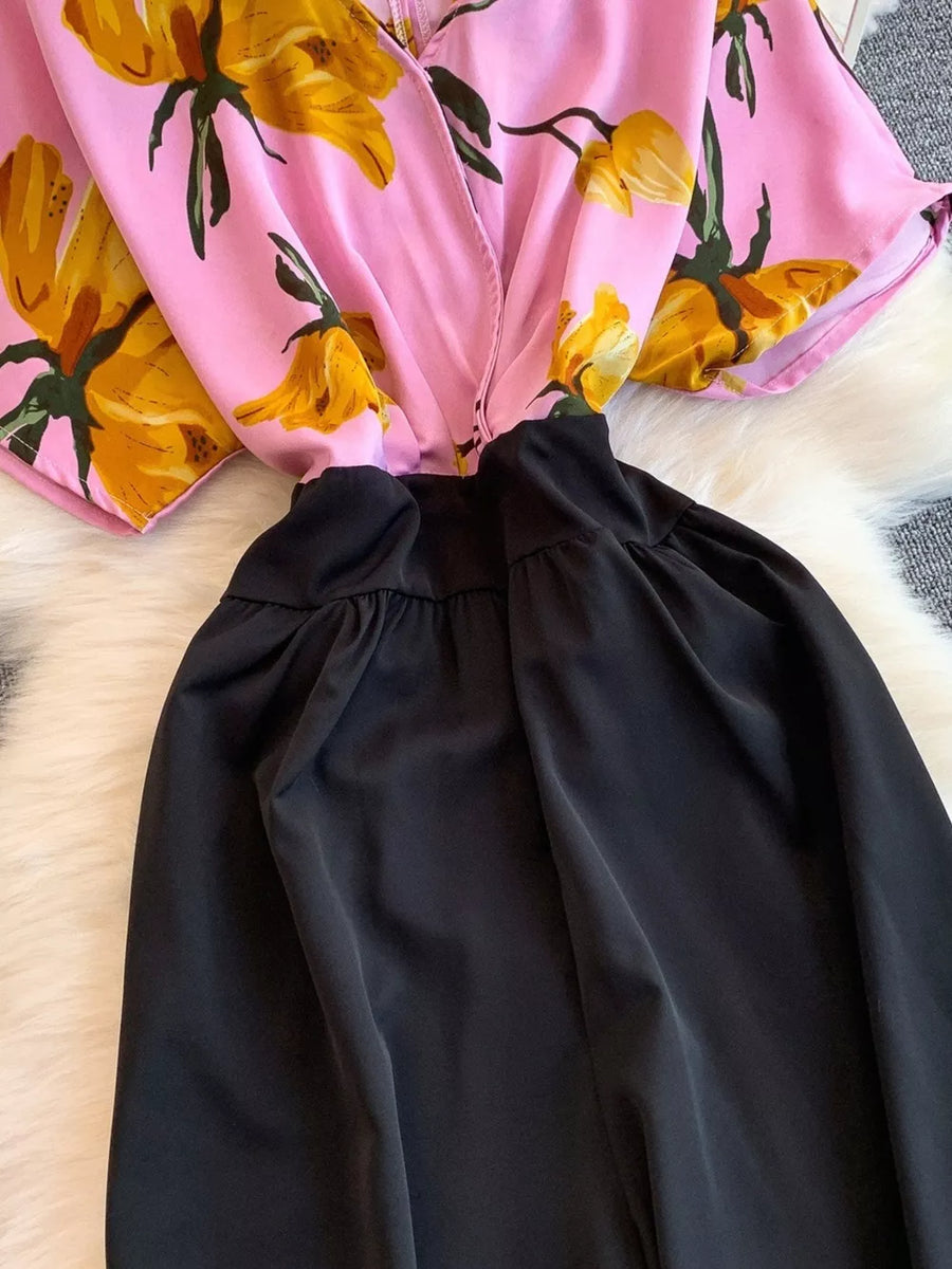 Pink abstract floral print romper with black wide-leg pants and pockets.