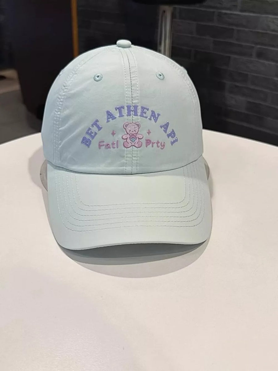Light blue baseball cap with embroidered teddy bear and text detail