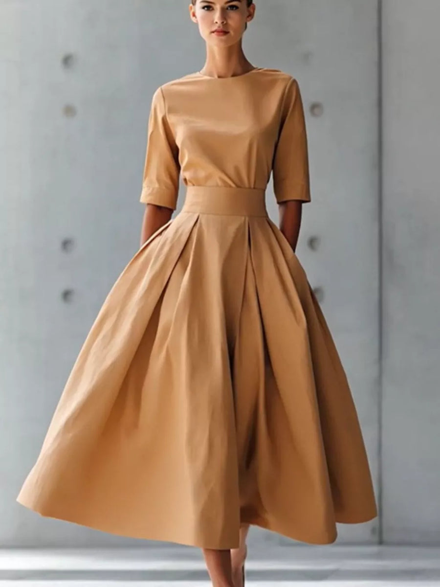 Camel A-line midi dress with pleated skirt, crew neck, and three-quarter sleeves.