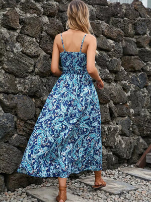 Maxi dress with blue paisley print, smocked bodice, spaghetti straps, and flowing skirt.