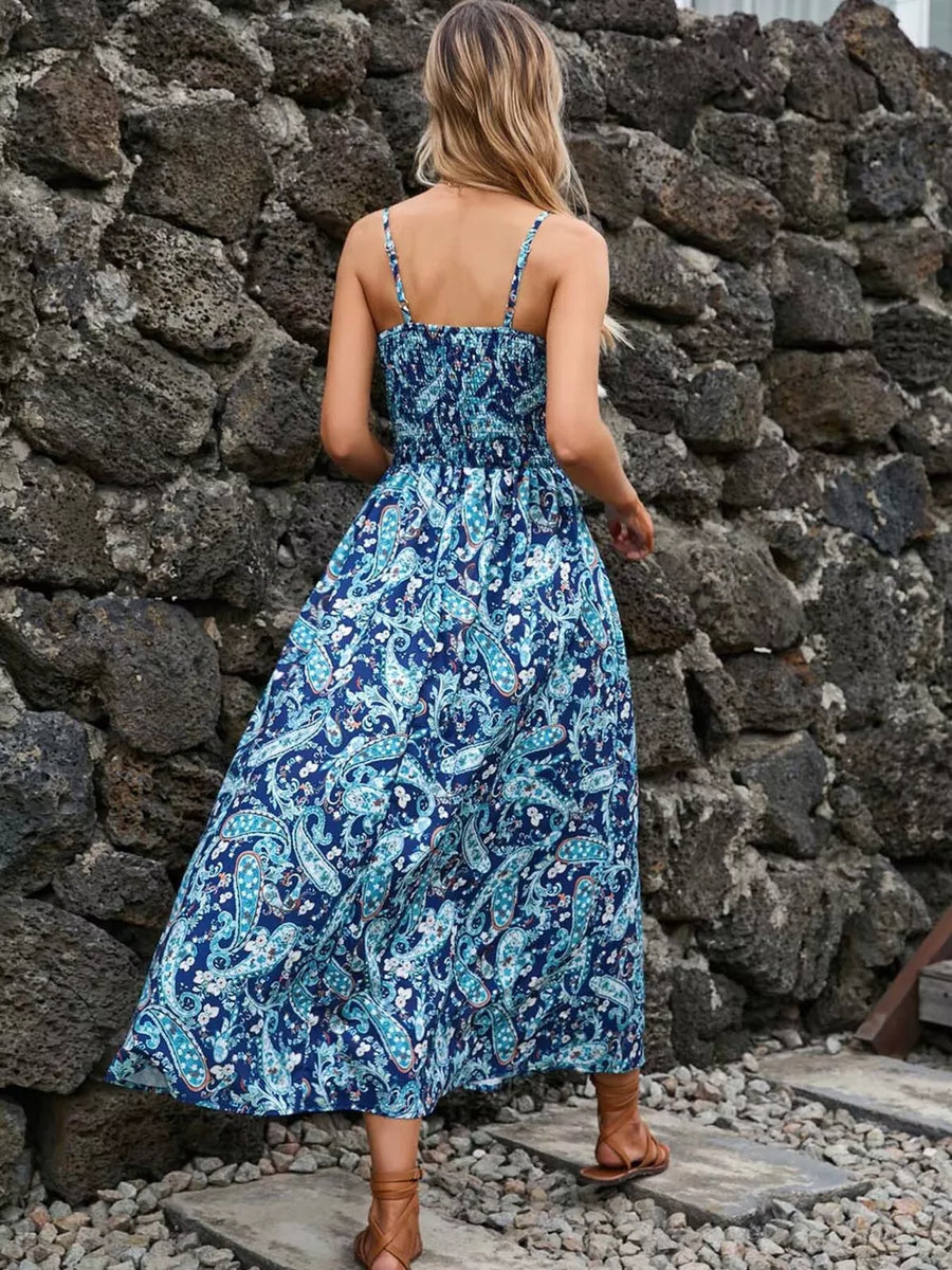 Maxi dress with blue paisley print, smocked bodice, spaghetti straps, and flowing skirt.