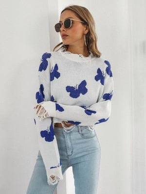 White cropped knit sweater with blue butterfly print and distressed details.