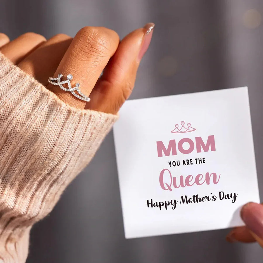Silver crown motif pave ring with sparkling stones on a hand holding a Mother's Day card.