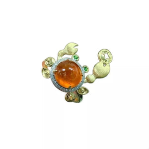 Gold crab ring with orange gemstone and green accents