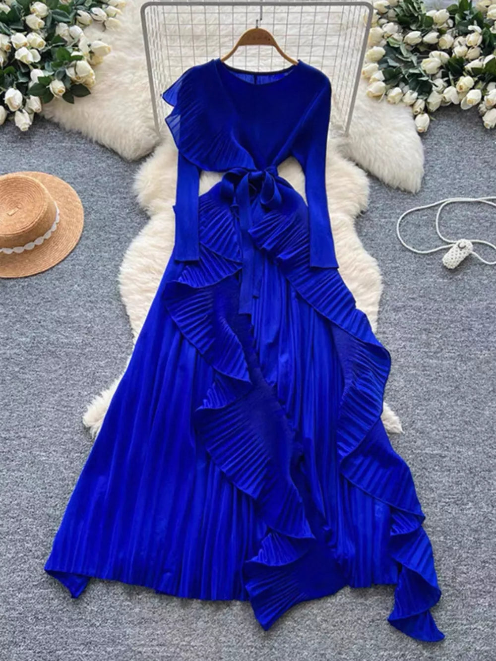 Royal blue midi dress with long sleeves, ruffled neckline, pleated skirt, and tie waist.