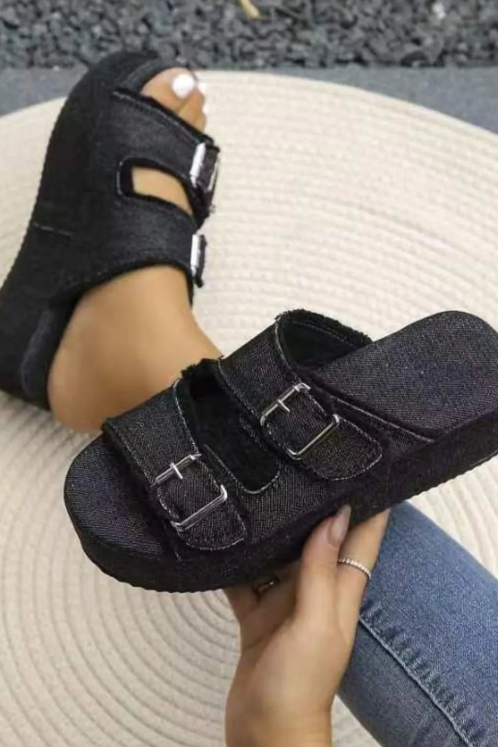 Black denim platform slides with double buckle straps.