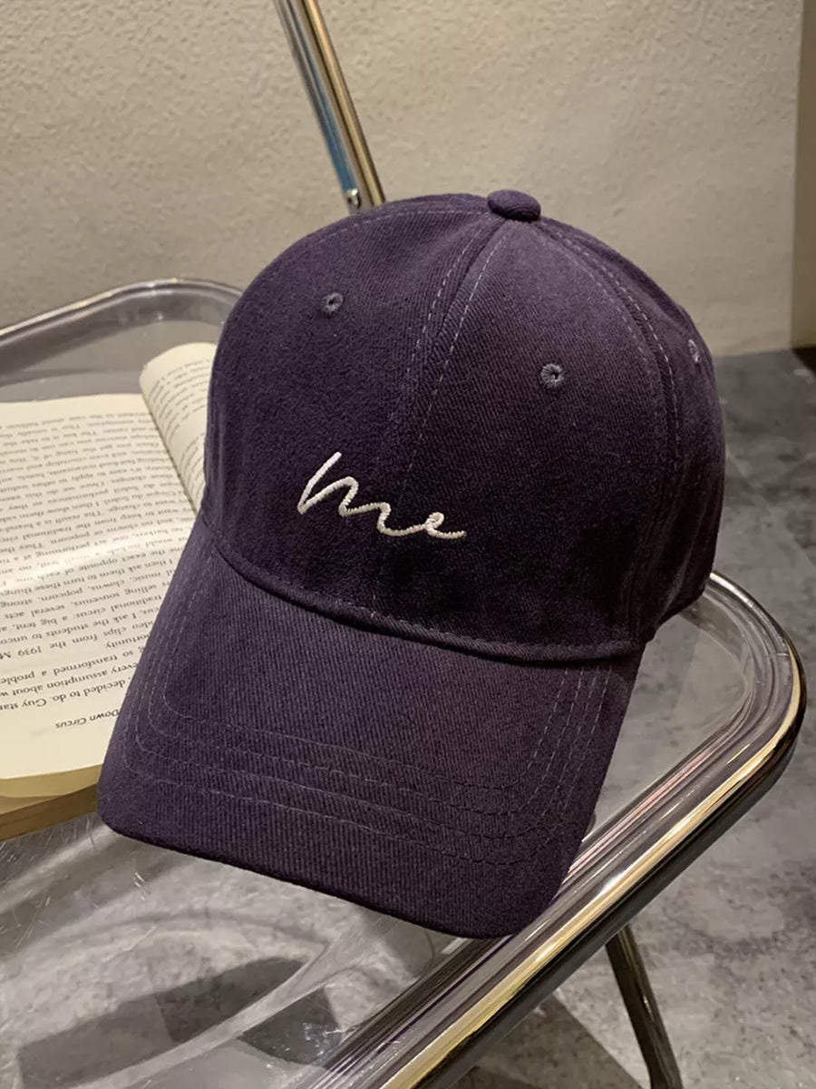 Navy blue cotton baseball cap with curved brim and white embroidered "me" detail.