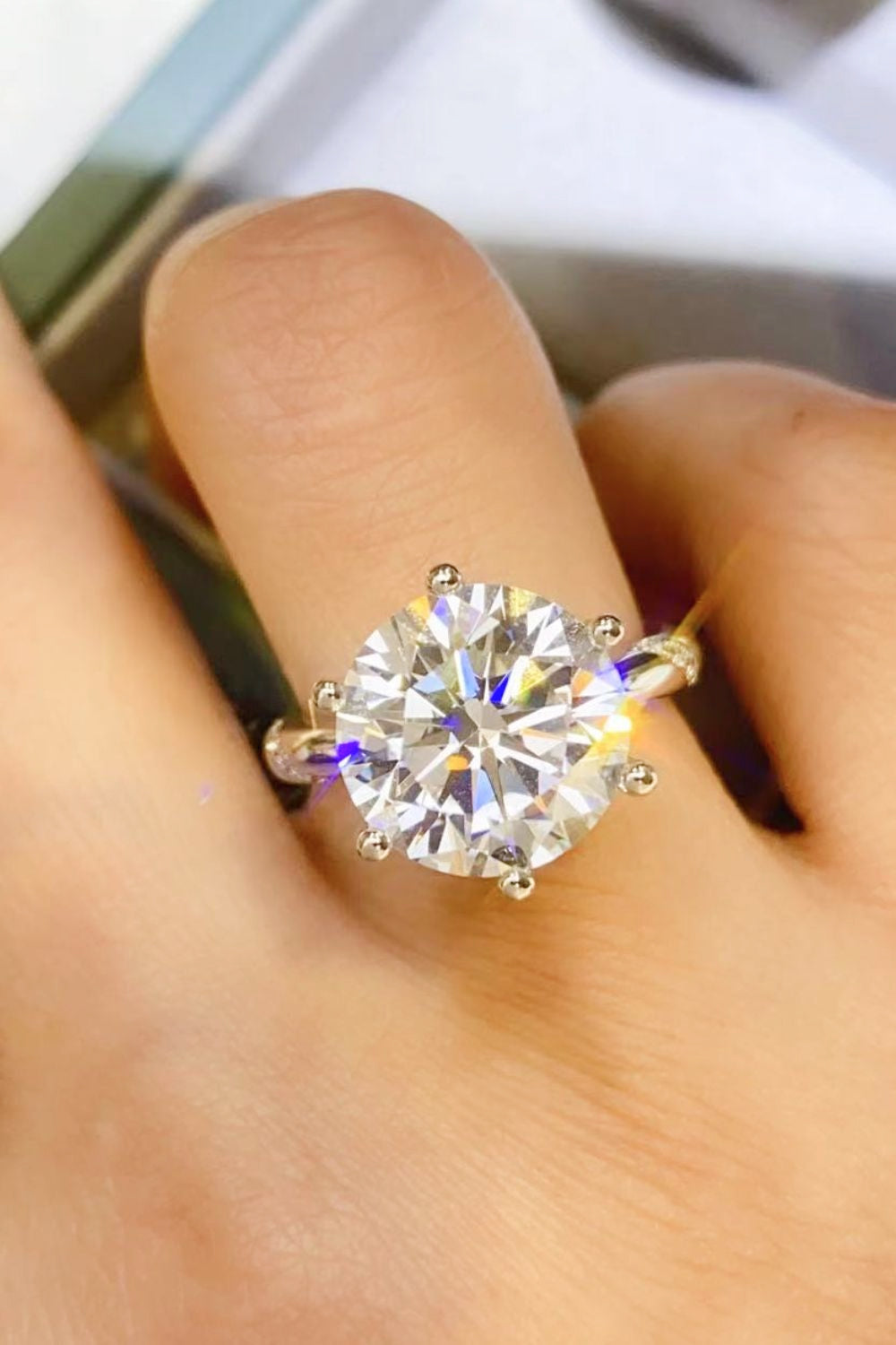 Solitaire crown engagement ring in silver with a large, round-cut diamond.