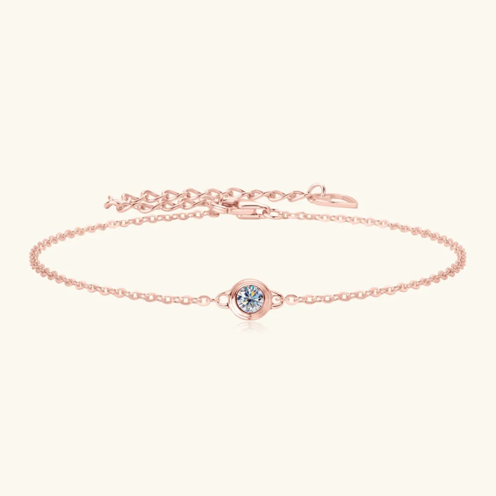 Rose gold chain bracelet with a single round moissanite stone in a bezel setting.