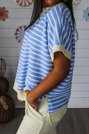Relaxed fit blue and white striped t-shirt with light yellow trim and short sleeves.