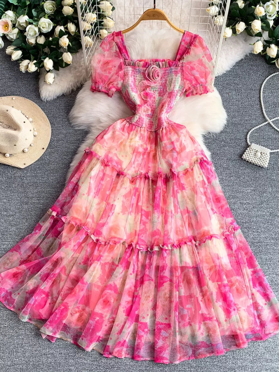 Floral tiered midi dress in pink with smocked bodice and puff sleeves.