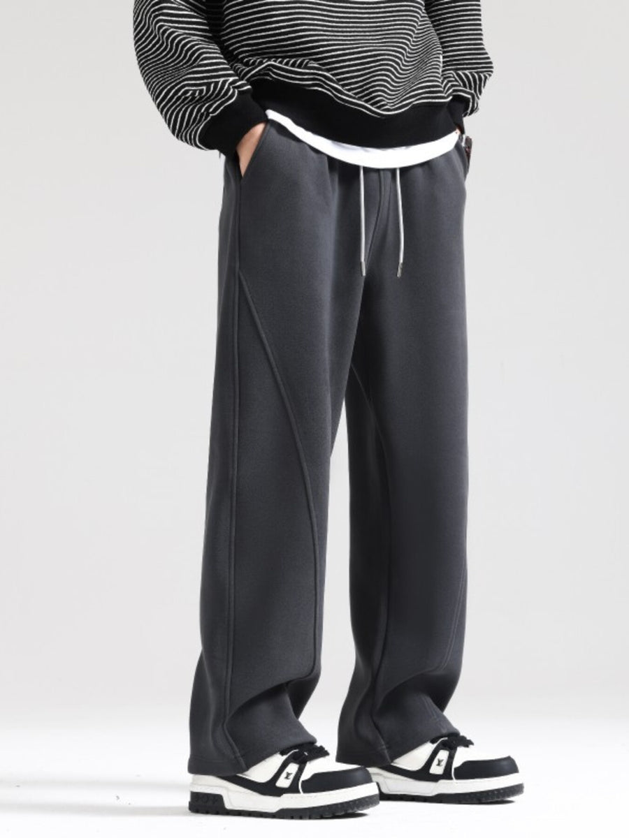 Men's grey wide-leg sweatpants with drawstring and seam detail.