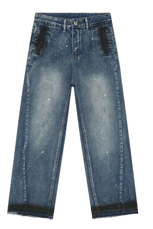 Panelled denim palazzo trousers in medium wash with paint splatters and black accents.