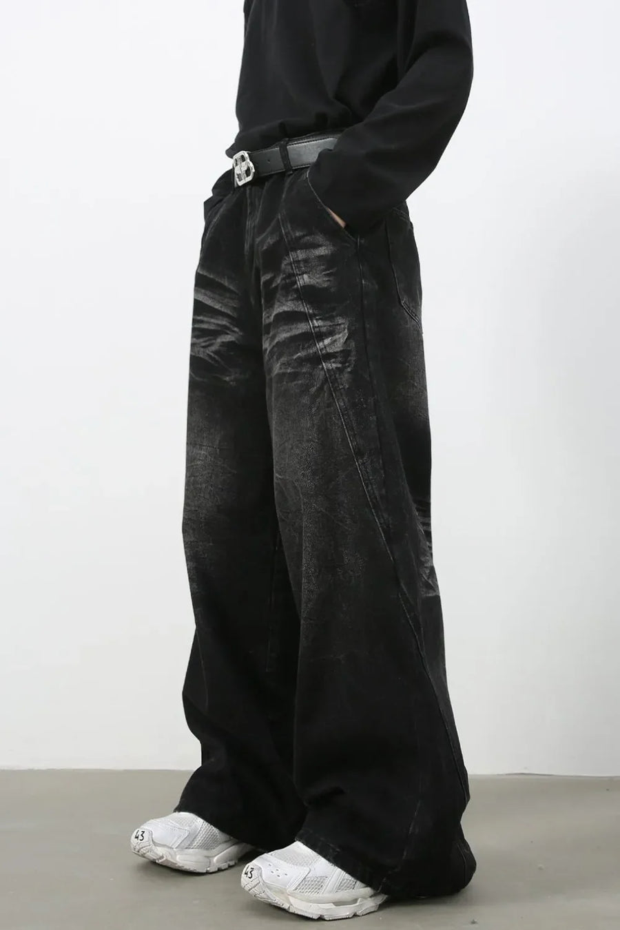 Faded black palazzo jeans in distressed denim with a wide leg and a casual fit.