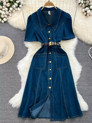 Dark blue denim collared midi dress with short sleeves, gold buttons, belt, and pockets.