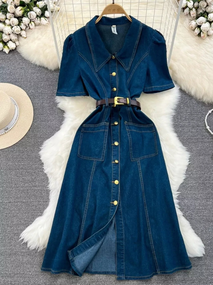 Dark blue denim collared midi dress with short sleeves, gold buttons, belt, and pockets.