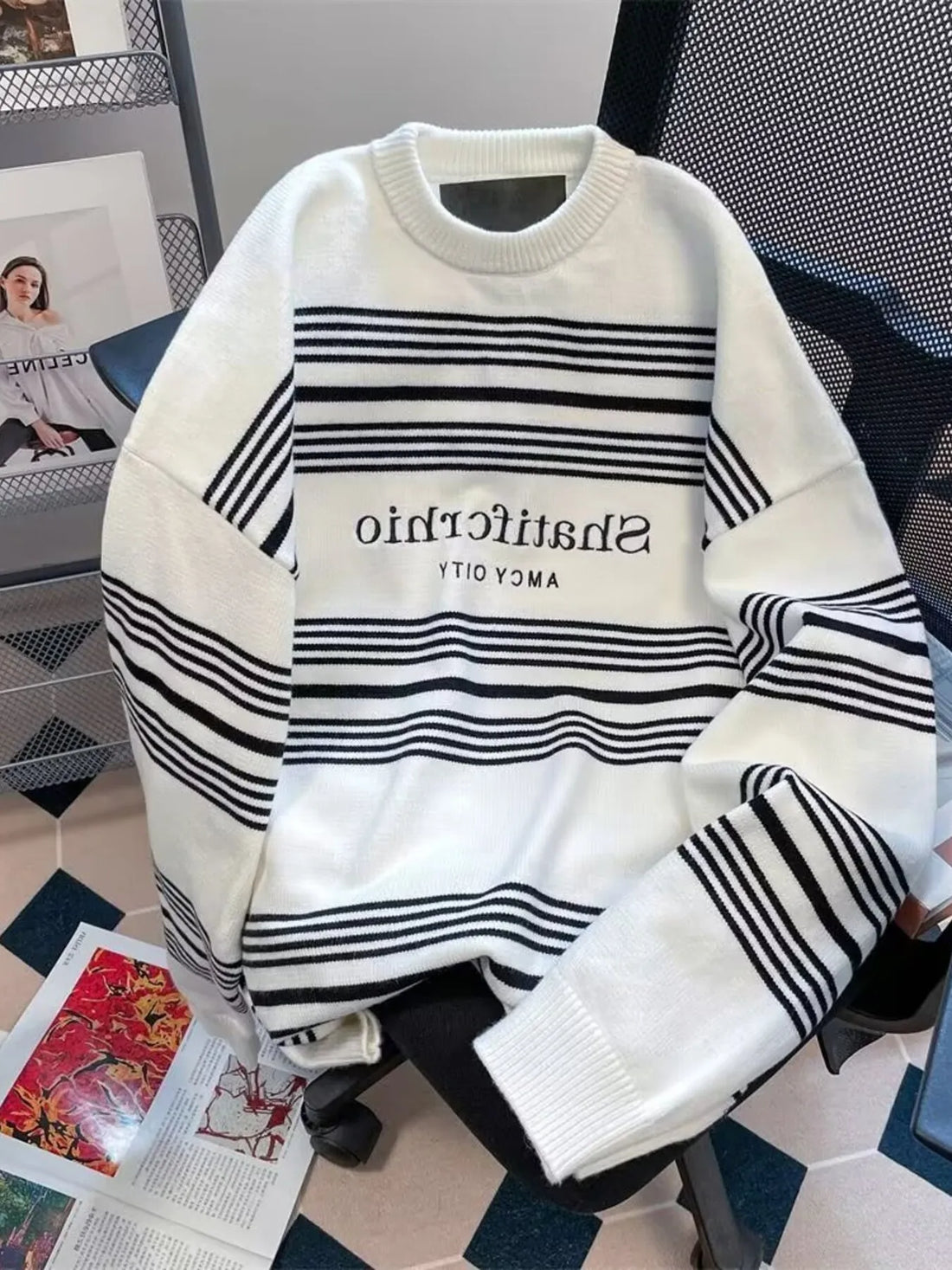 Men's white knit sweater with black horizontal stripes and embroidered text.