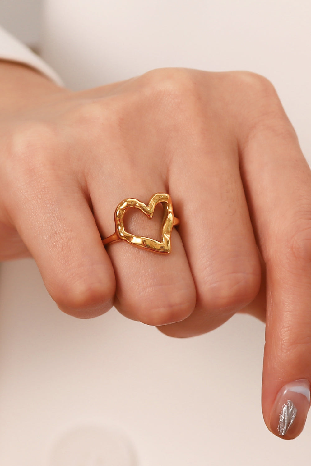 Gold sculpted heart signet ring with an open design