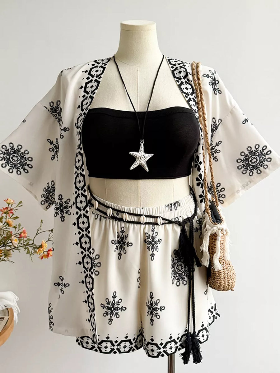 White polyester shorts and open cardigan set with black embroidered pattern and tassel belt.