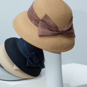 Elegant straw sun hat in Khaki with a sheer brown bow embellishment.