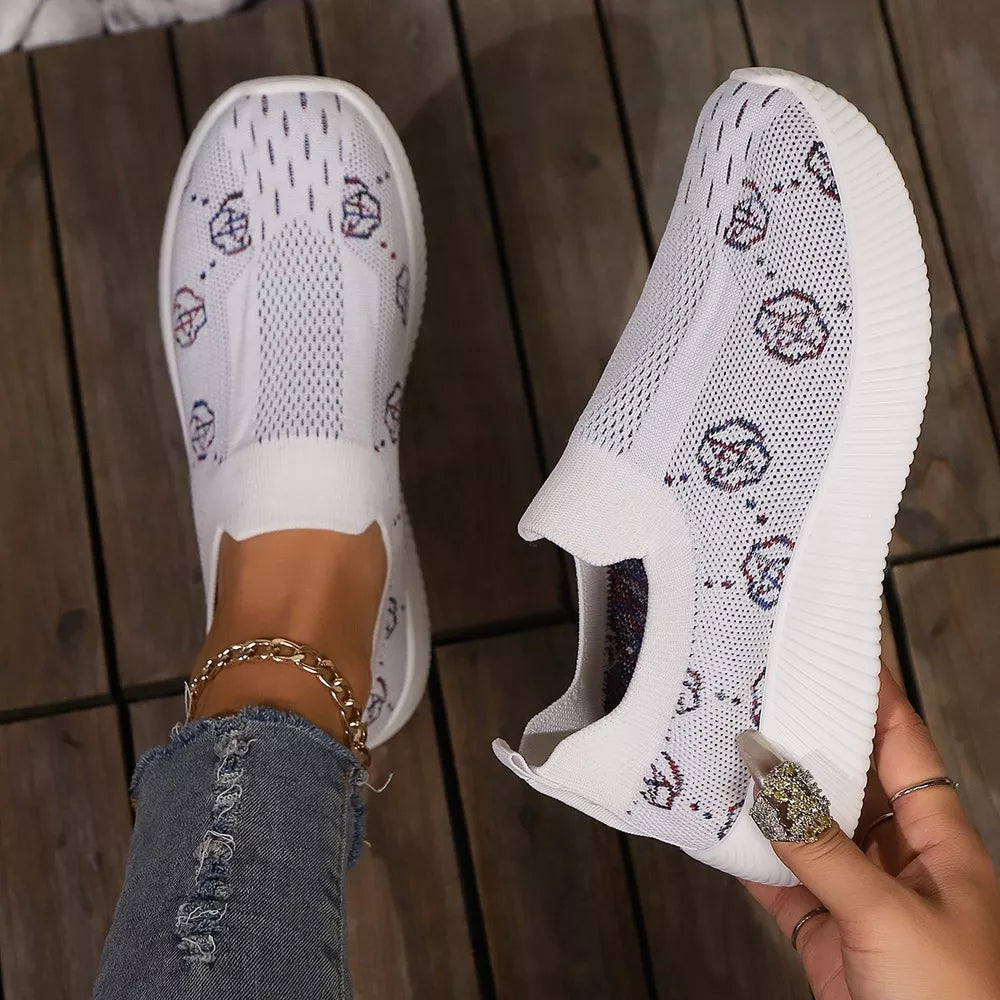 White breathable mesh slip-on sneakers with a graphic pattern and comfortable fit.