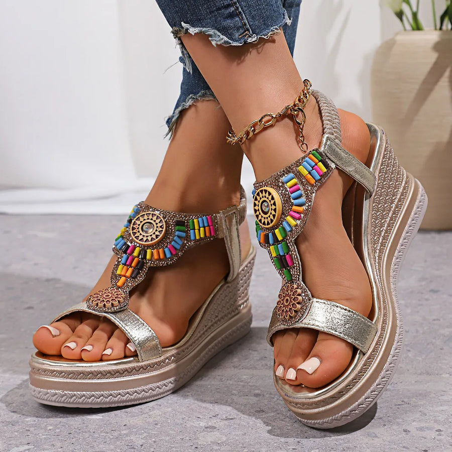 Gold embellished platform wedge sandals with colorful beads and a t-strap design.