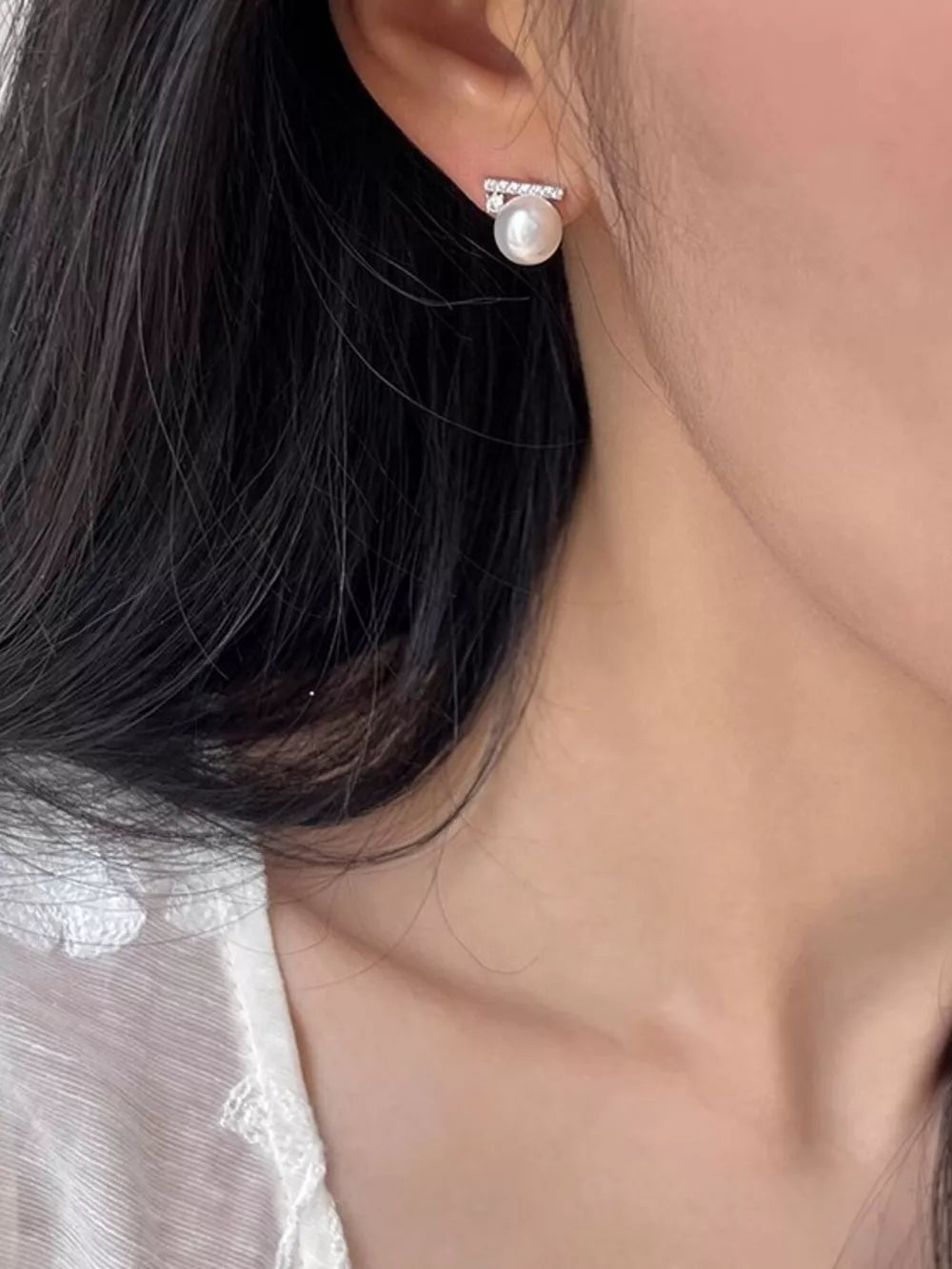 White pearl stud earrings with a bar of clear zircon accents.