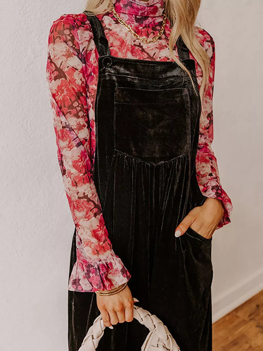 Black velvet wide-leg maternity romper with front pockets and ruffled floral top.