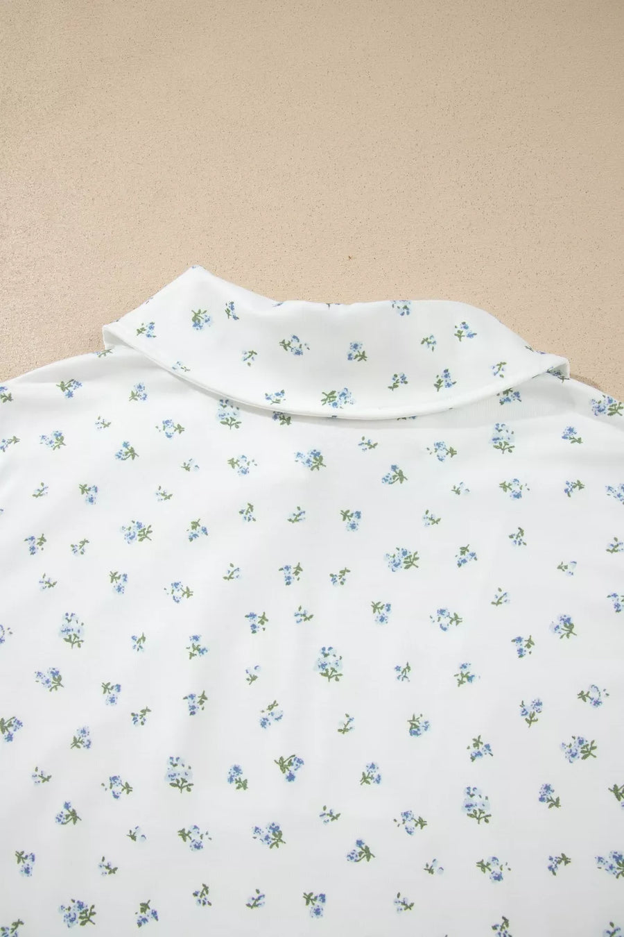 White collared shirt with a blue floral print and green stems