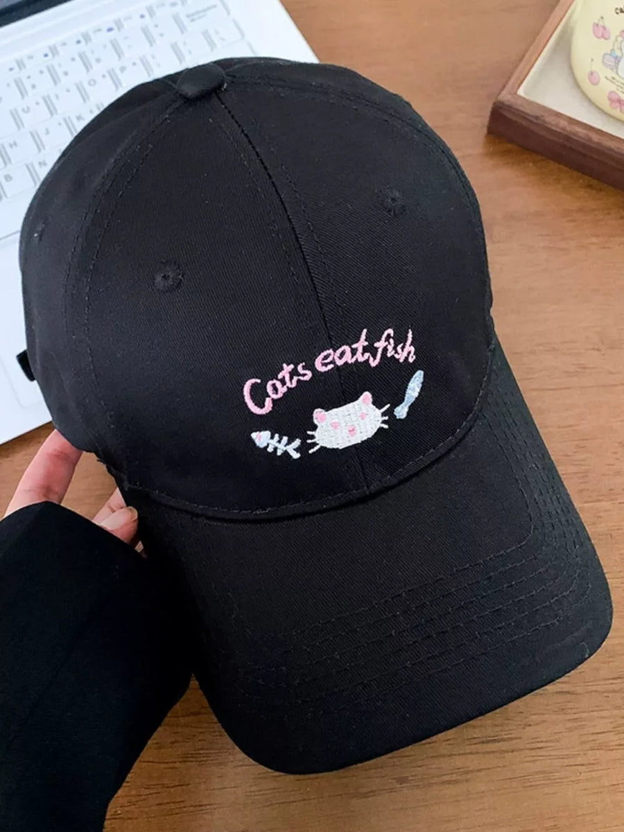 Black baseball cap with pink cat and fishbone embroidery and text.